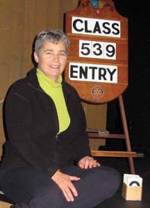 BY THE NUMBERS: Volunteer Wendy Mann poses with one of her favourite volunteer jobs at the Festival of Performing Arts: changing the numbers on the board.